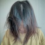 疲れてお風呂に入れずベッドに伏せている人のシルエットと暗い室内
