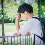 就活で仮面をかぶって本来の自分を隠している学生のイメージ