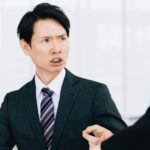 上司に叱責されて落ち込む社員と、それを心理的に受け流すイメージ