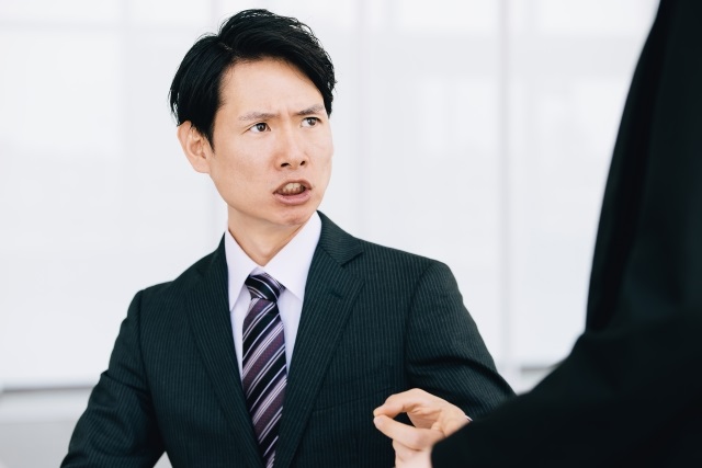 上司に叱責されて落ち込む社員と、それを心理的に受け流すイメージ