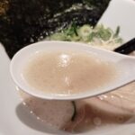 豚骨ラーメンのスープを飲み干す人と、塩分・脂質のイメージを示す健康リスク表現