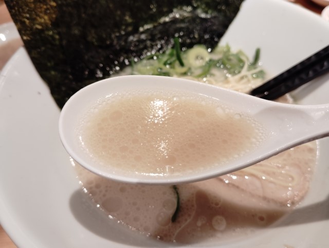 豚骨ラーメンのスープを飲み干す人と、塩分・脂質のイメージを示す健康リスク表現