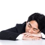夜中に目覚めて時計を見る女性と、安眠できず悩む様子を描いたイメージ