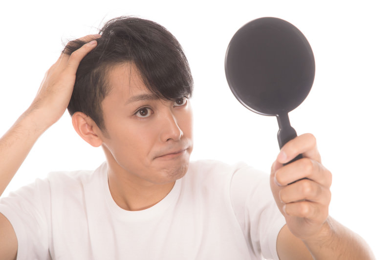 髪の毛の健康を気にする男性のイメージ