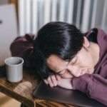 昼食後に眠気と戦うビジネスパーソンと眠気防止に適した健康食材